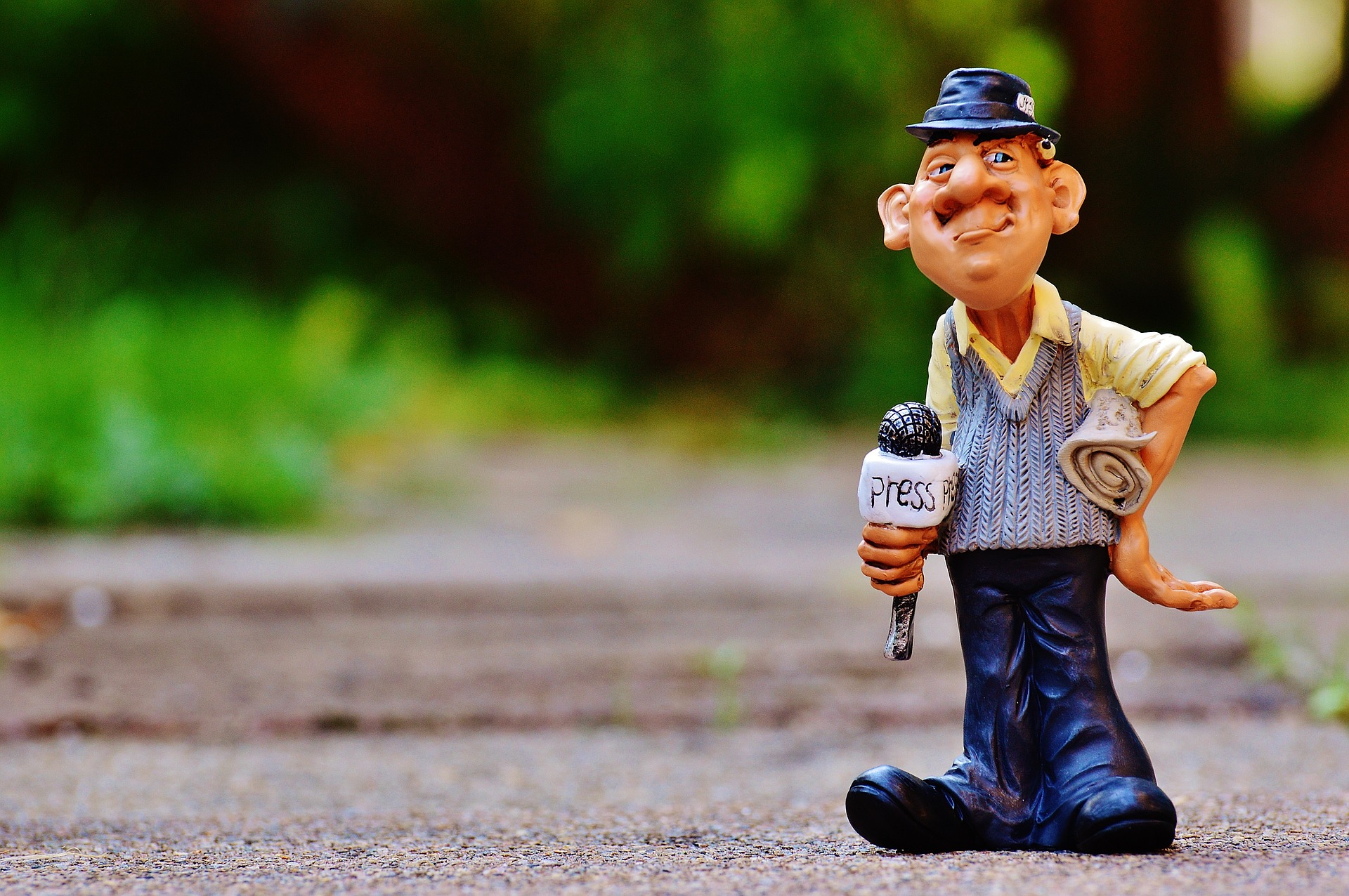 photo of a tacky lawn ornament that looks like an elderly journalist holding a microphone with the word 